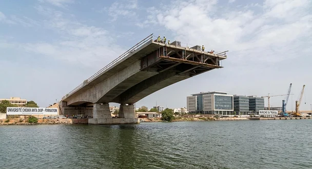Pont en construction n’atteignant pas l’autre rive symbolisant le fossé entre formation universitaire et marché du travail